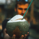 A água de coco ajuda a combater a ressaca - Ela é um “santo remédio” para curar a ressaca. Além da hidratação, como já explicado, o açúcar presente na bebida ajuda naturalmente a elevar a glicemia, e ajuda a combater os sintomas de mal estar e inchaço. (Foto: Unsplash)