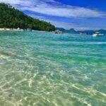 O espaço fica entre o mar com coloração bem esmeralda, quase sem ondas e uma areia bem branquinha. (Foto: Pinterest)