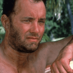 Tom Hanks foi parar no hospital durante as gravações do filme "Naufrágo". Isso porque enquanto gravava uma das cenas na praia, o ator fez um sério corte na perna. (Foto: Divulgação)