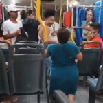 No vídeo, a mulher aparece ajoelhada no corredor do ônibus, já fora de sua cadeira de rodas. Ela se aproxima de outra passageira e, em questão de segundos, ambas começam a trocar agressões físicas, enquanto os outros passageiros assistem à cena sem intervir de imediato. (Foto: Reprodução/Redes Sociais)