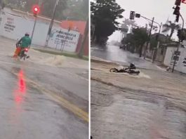 Um vídeo divulgado nas redes sociais mostra um motociclista que aparece sendo levado pela enxurrada ao tentar atravessar para o outro lado da avenida. (Foto: Reprodução)