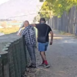 O homem, vestido com uma camisa xadrez preta e branca, parecia estar em "transe", disseram testemunhas. Um outro homem se aproximou dele e apagou o pequeno incêndio com uma garrafa de água. (Foto: Reprodução/Paul Haddad)